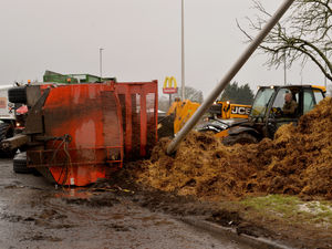 Supporting image for story: Overturned trailer leaves large mound of manure on roadside near busy roundabout