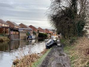 Supporting image for story: Oil leak from abandoned burned out car flows into canal