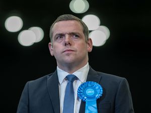 Douglas Ross looking concerned, wearing a Conservative rosette