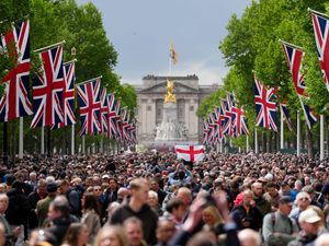 Members of the public along The Mall watch the flypast following the military procession to mark the 80th anniversary of VE Day on Monday
