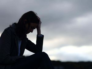 Profile of a sad woman silhouette sitting outdoors