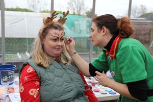 Student Lucy has her face painted by Sarah