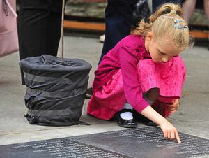 A little girl looks at the names of the fallen after the dedication ceremony in Ludlow's Castle Square