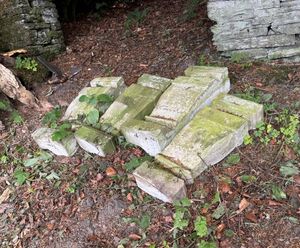 Four corner stone supporting pillars were forcibly removed from a raised tombstone style grave