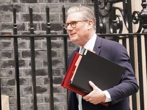 Sir Keir Starmer walking along Downing Street carrying folders