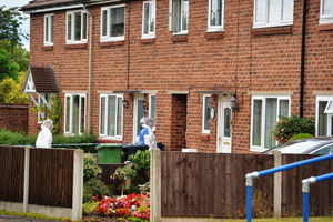 Forensic investigators enter a property