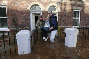 Margaret McCraken, 79, is helped from her home in Broad Street in Carlisle