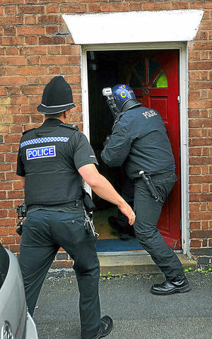 Police officers enter a house