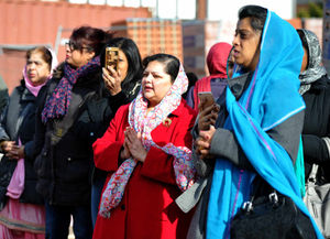 People watch as the flag pole is raised