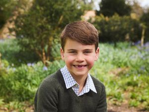 Prince Louis smiling, showing a gap where his front teeth are missing